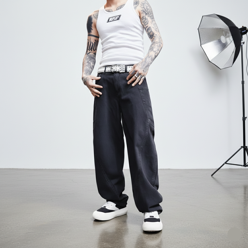 Person wearing a white tank top and black pants standing in a studio setting with photography equipment.