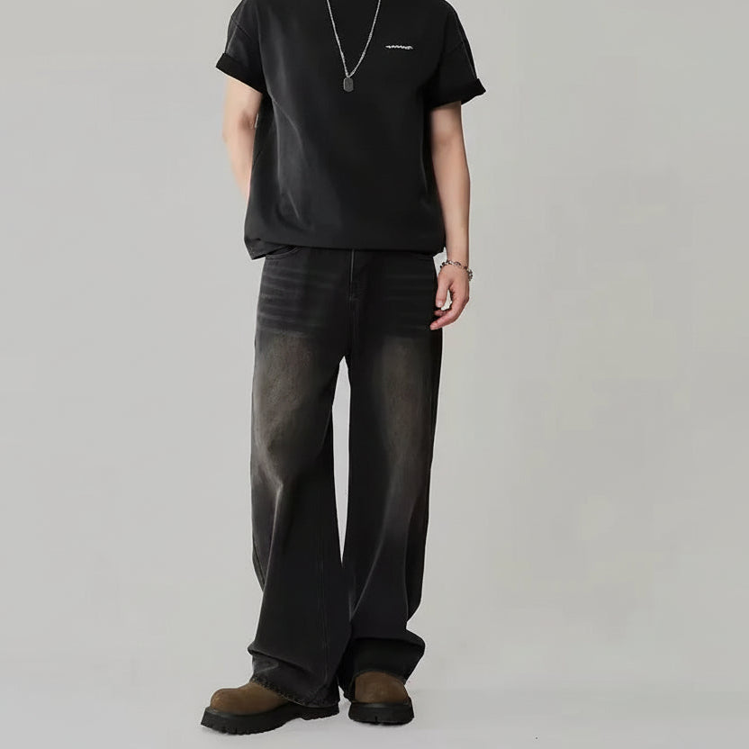 Person wearing a black outfit with wide-leg pants on a plain background.