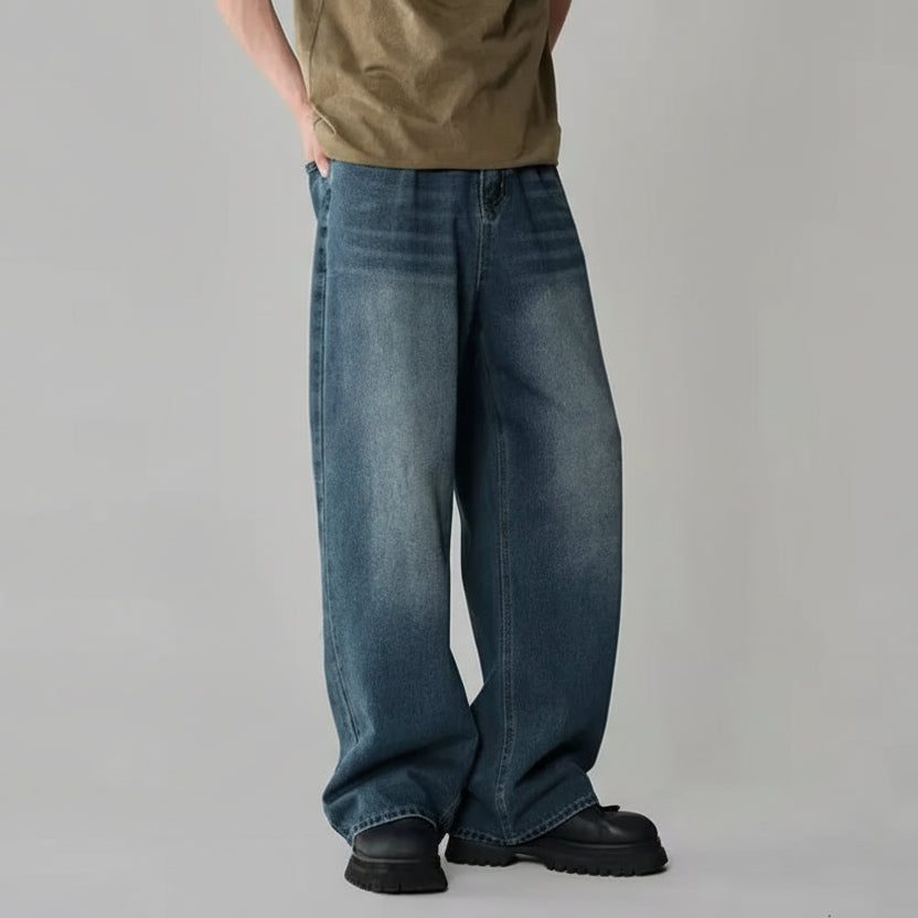 Person wearing blue jeans on a gray background.