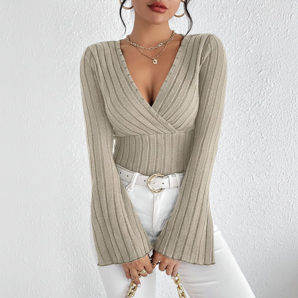 Woman wearing a ribbed knit top with a deep neckline against a white background